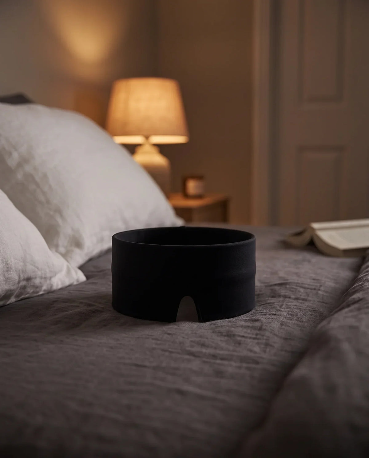 The cap resting on the bed, open ring